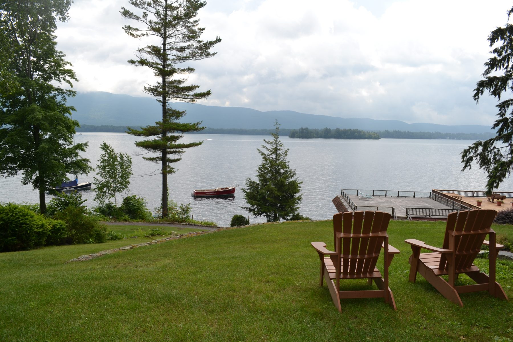 Adirondack chairs on grass looking out onto lake george