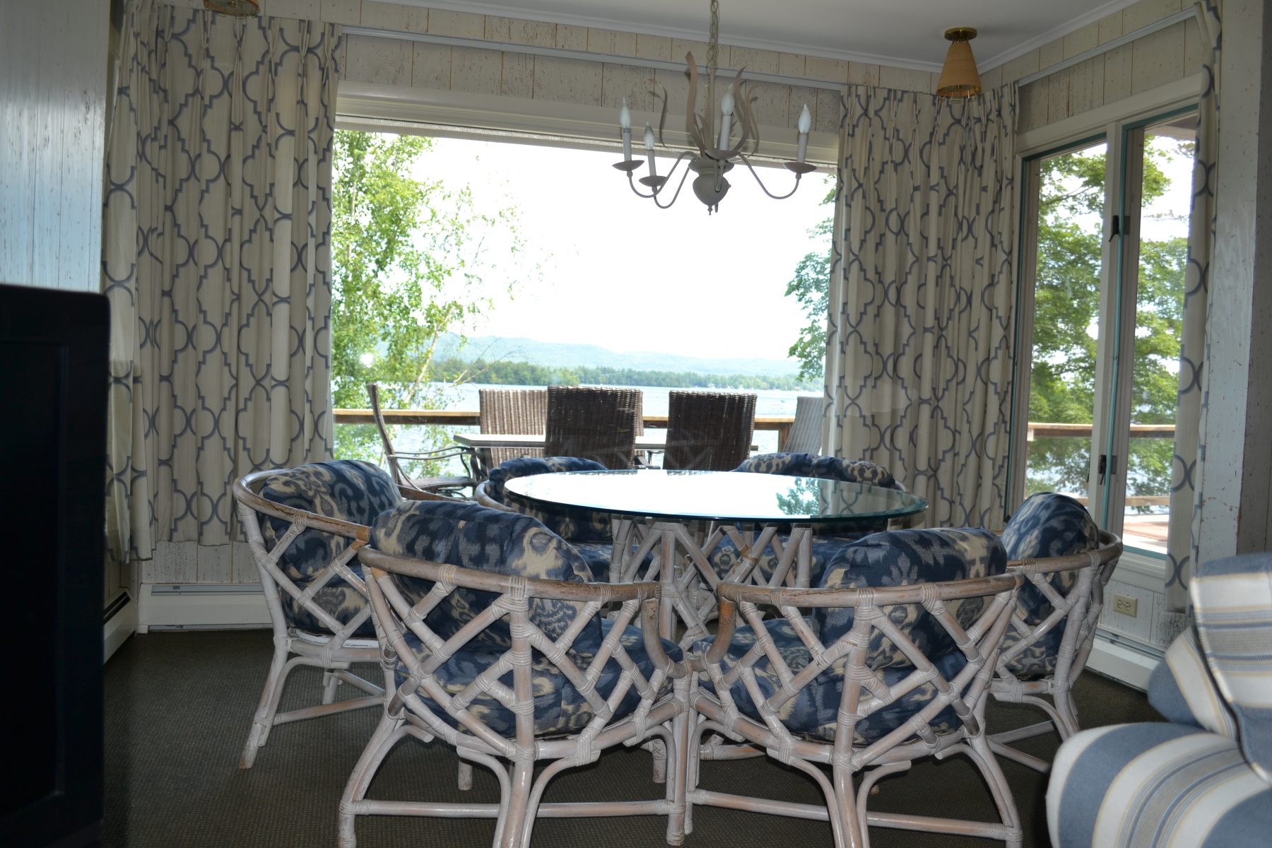 Round glass table with chairs around looking out large bay window