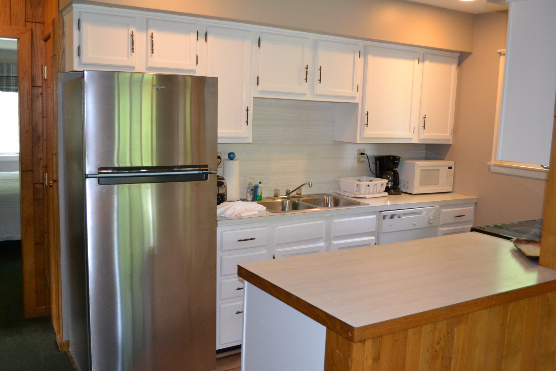 White cabinet kitchen with stainless refrigerator